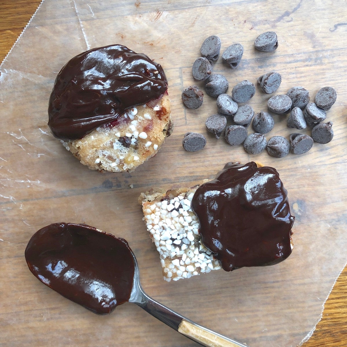 Fruitcake bars dipped in dark chocolate on a piece of waxed paper.